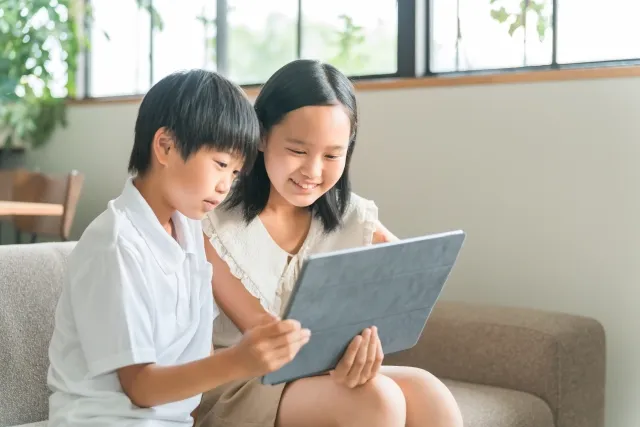 幼い男の子と女の子がタブレットで何かを見ている