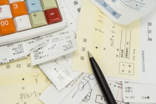 大量の領収書と電卓とボールペン